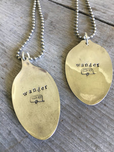 Close up of Stamped Spoon Necklaces Wander with Airstream Trailer