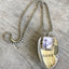 Close-up detail of LOVE stamped spoon pendant with pewter frame for photo, eco-friendly upcycled vintage silverware