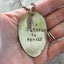 THE FUTURE IS FEMALE stamped spoon necklace held in hand for scale showing one of a kind feminist statement jewelry
