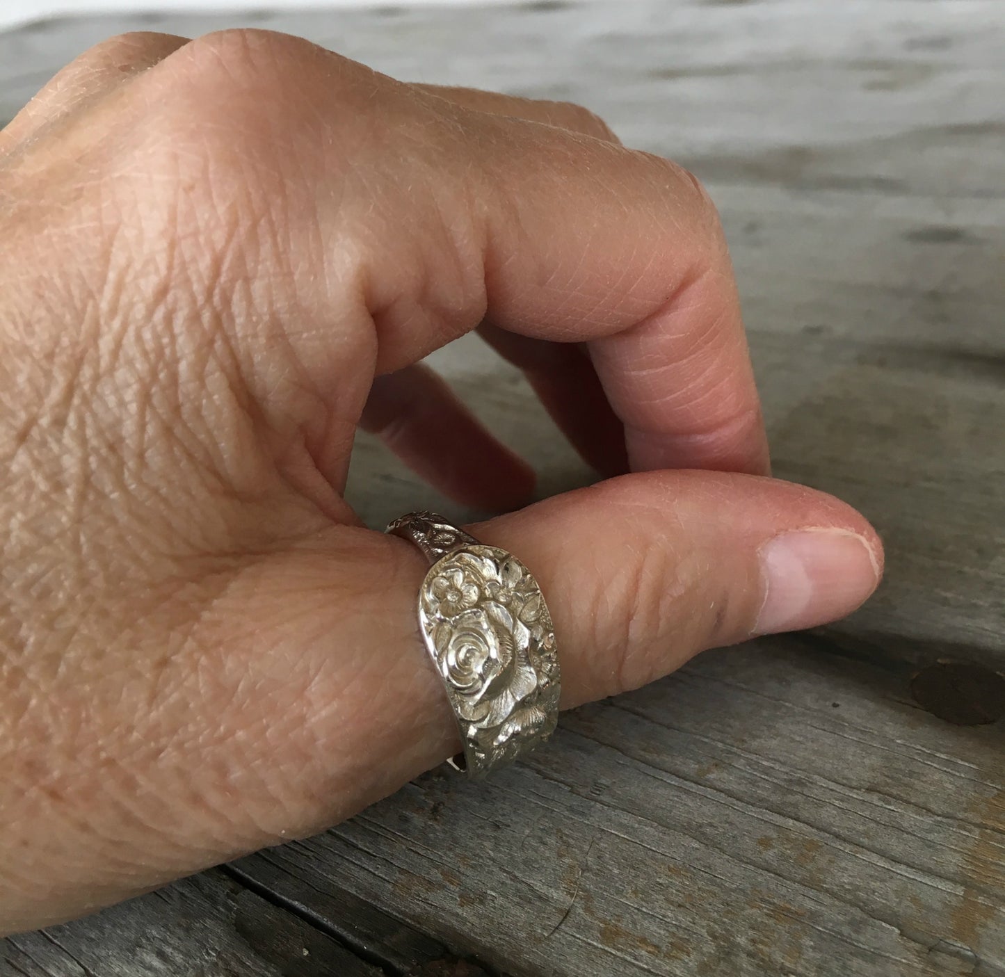 Kirk & Son Repoussé sterling silver spoon ring on hand displaying wearable fit and ornate floral pattern