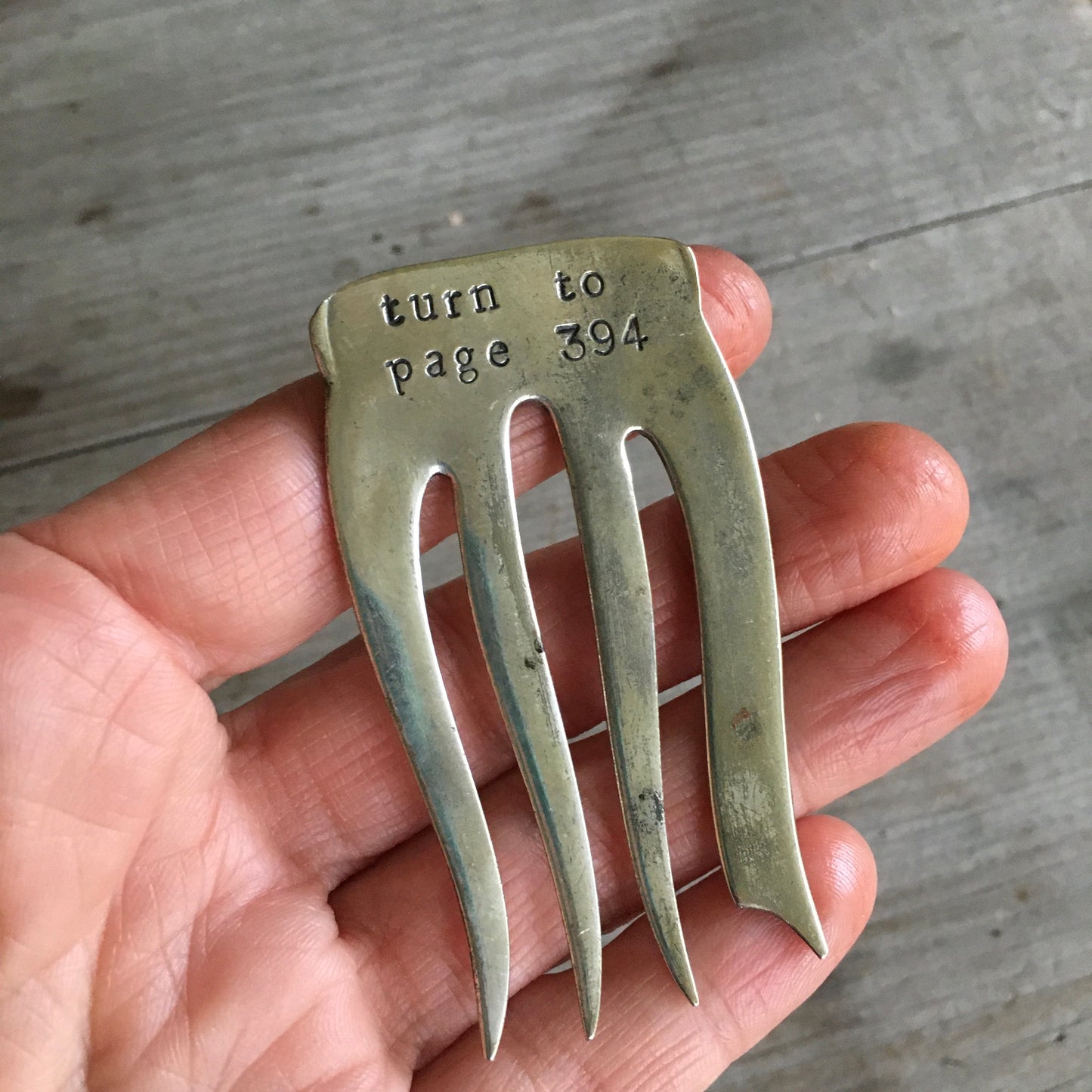 TURN TO PAGE 394 Bookmark shown in hand for scale