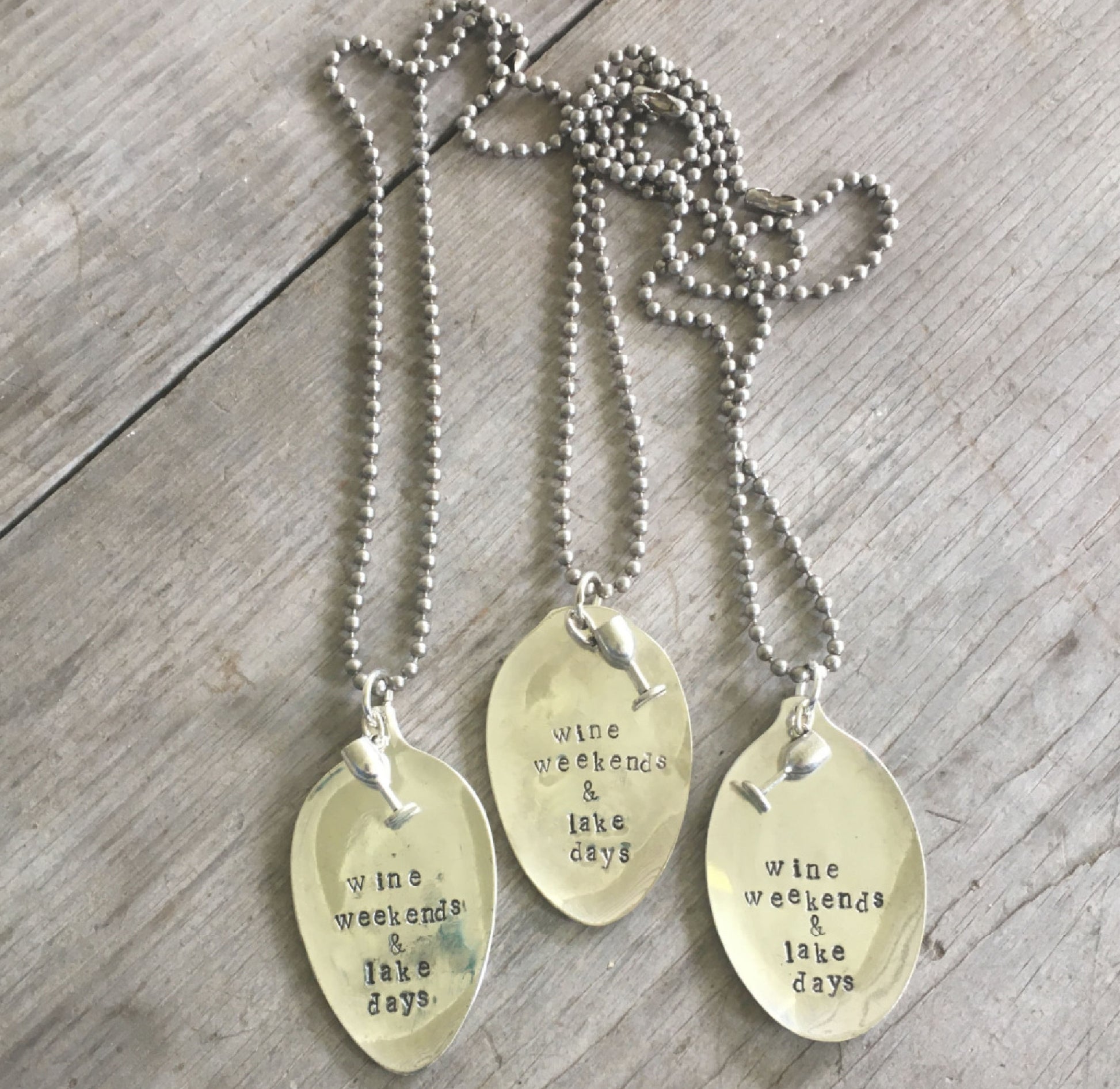 WINE WEEKENDS & LAKE DAYS spoon necklace with wine glass charm held in hand for scale, layerable carefree style on 1970s ball chain