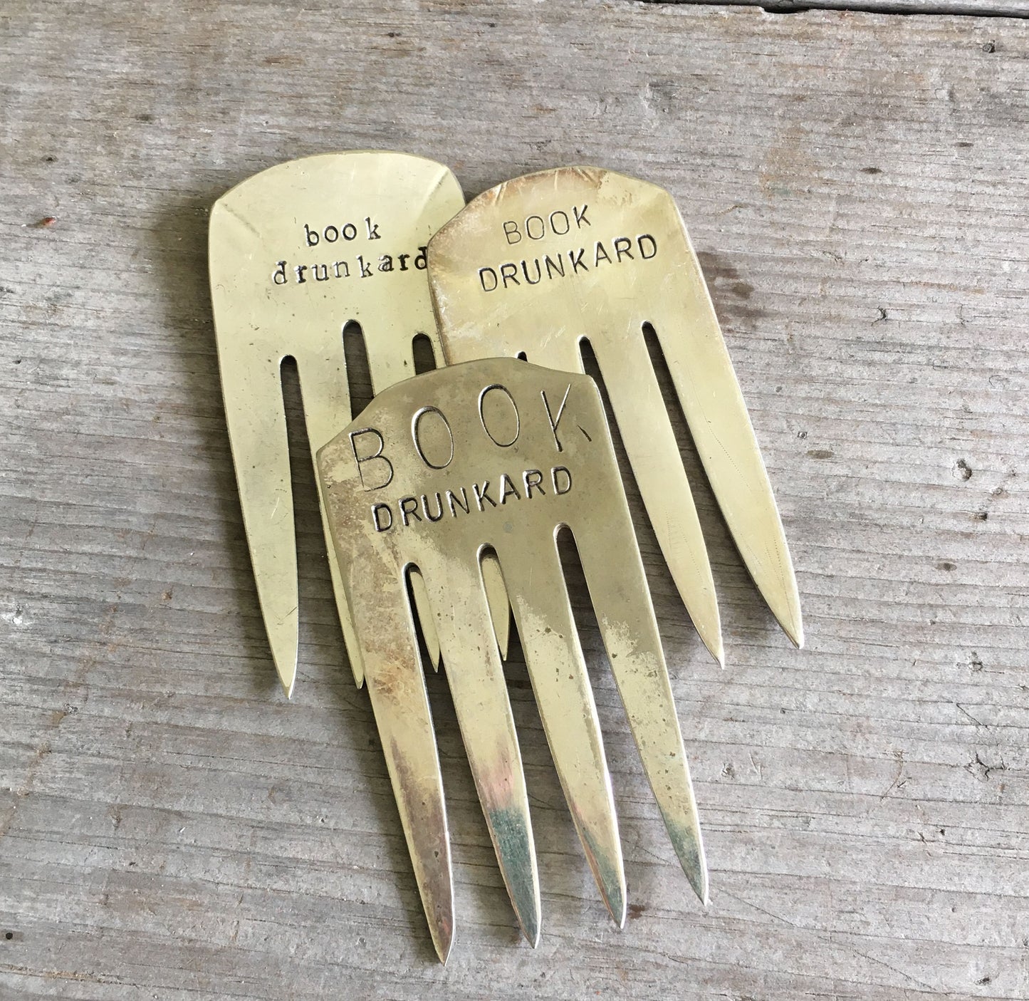 Collection of upcycled fork bookmarks including BOOK DRUNKARD and other literary designs