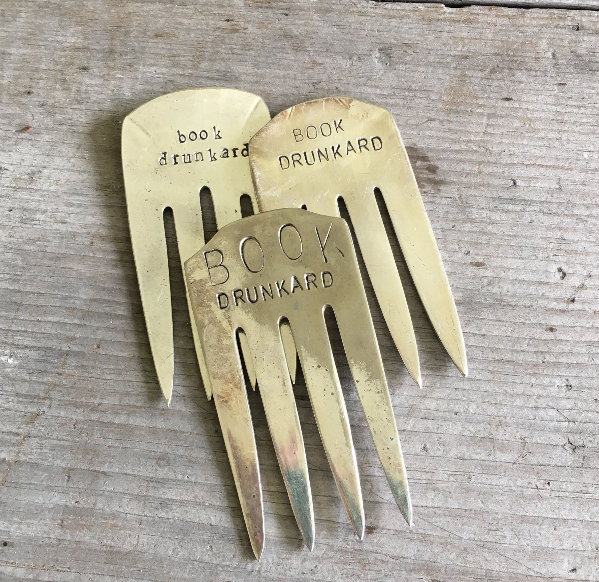 Collection of upcycled fork bookmarks including BOOK DRUNKARD and other literary designs