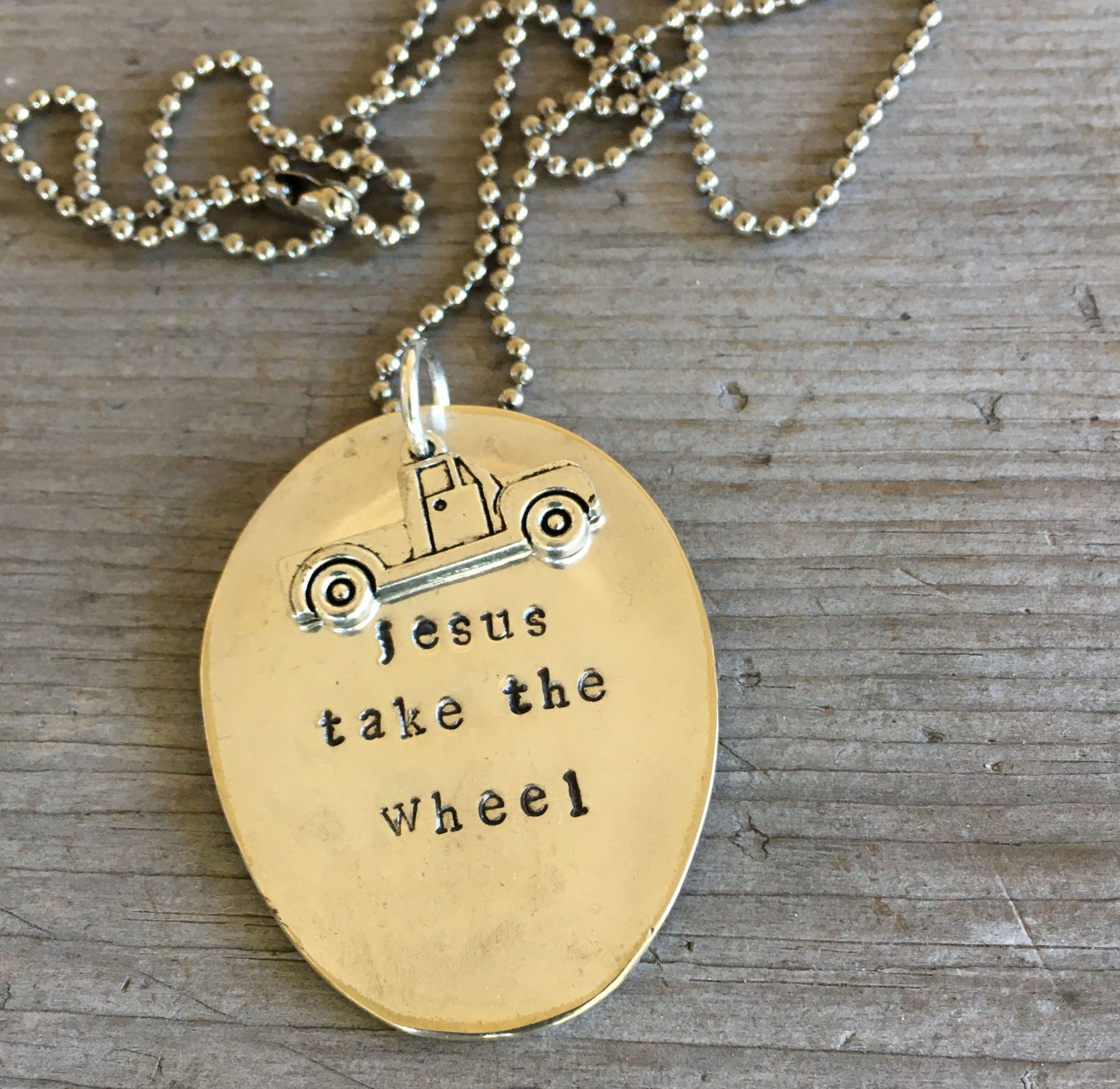Close-up of JESUS TAKE THE WHEEL hand-stamped spoon pendant with truck charm showing reclaimed vintage silverware, 3.375 inches long