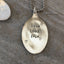 Detail of LIVE LOVE LAKE hand-stamped spoon pendant, soulful lake-themed design