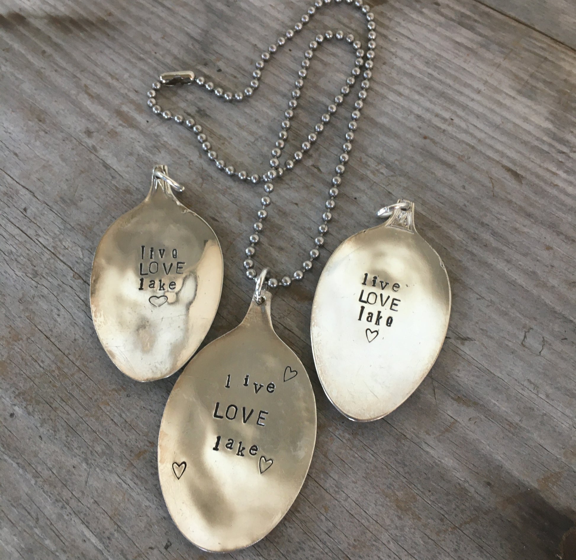Multiple LIVE LOVE LAKE hand-stamped spoon necklaces showing one-of-a-kind variations, reclaimed vintage silverware